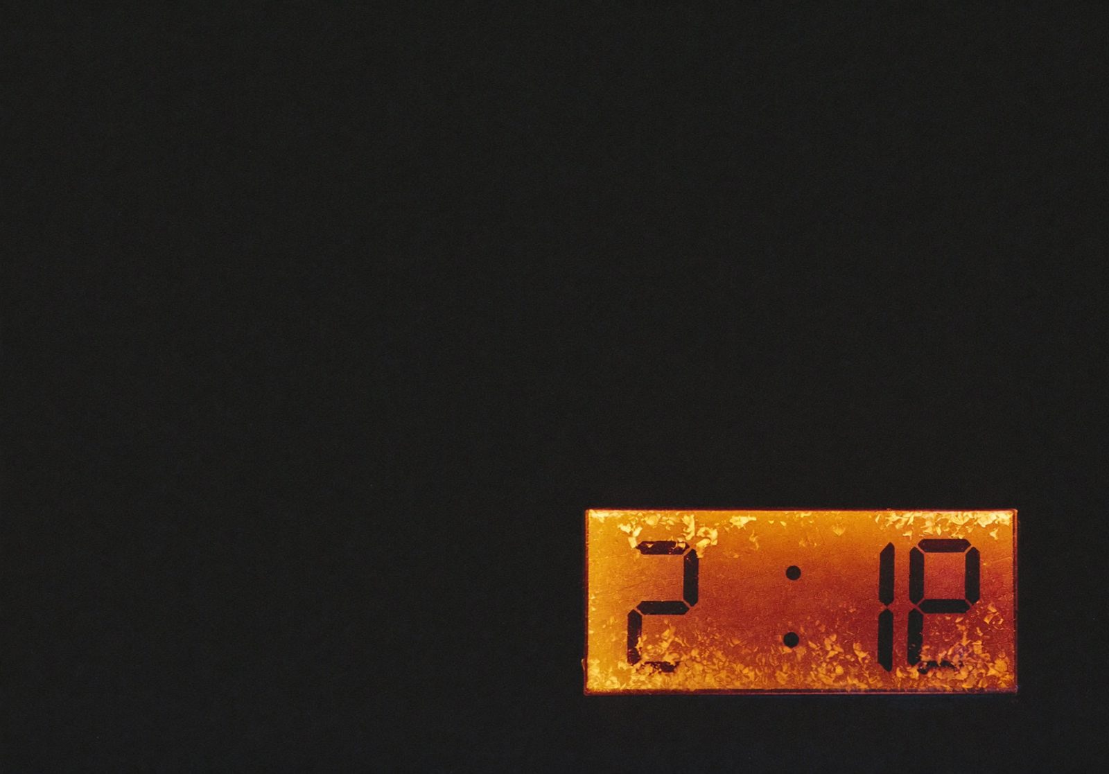 A frost-edged thermostat display glowing amber in a dark, cold room